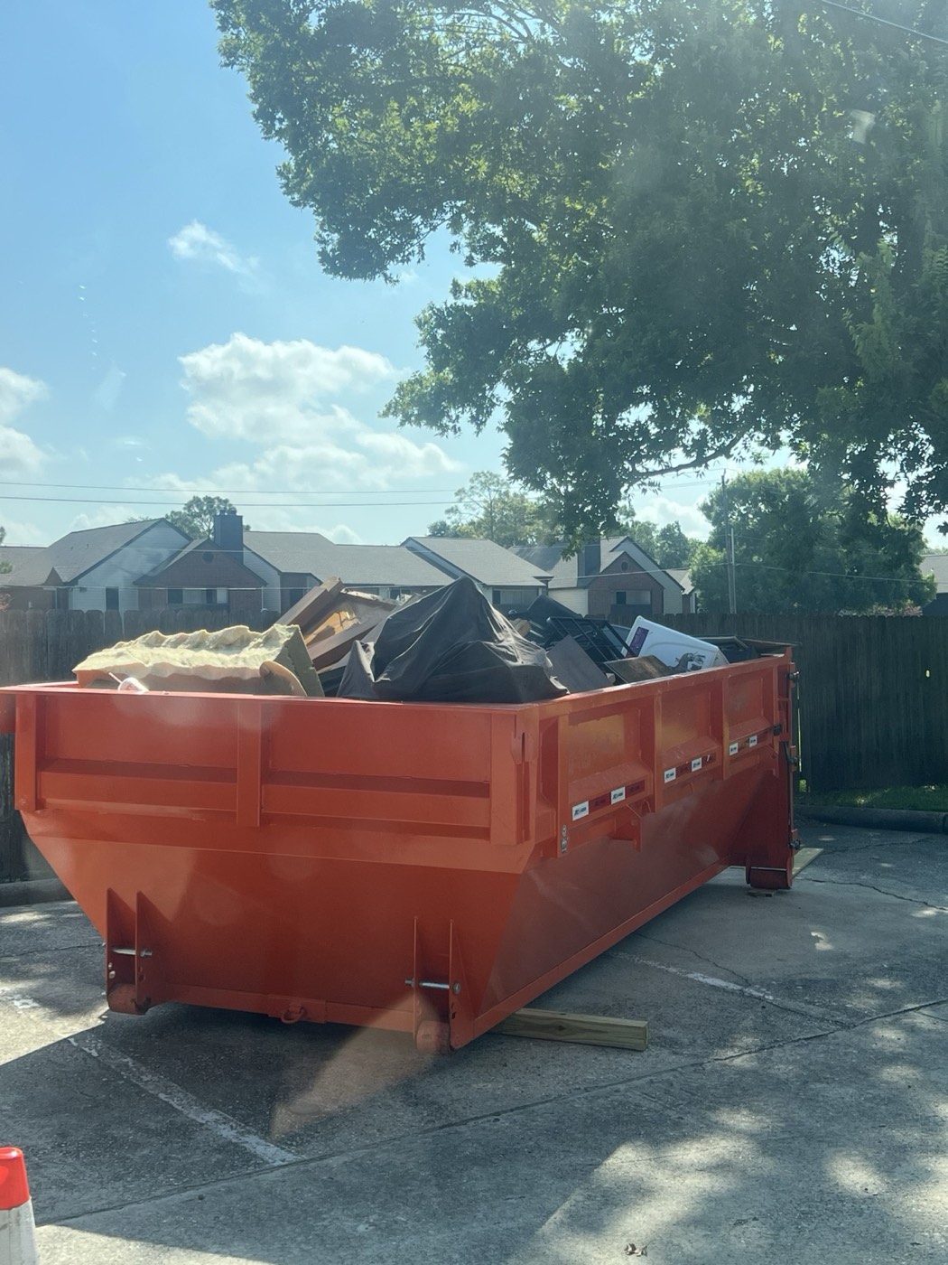 14-yard roll-off can loaded full with a mattress, insulation, furniture and bags
