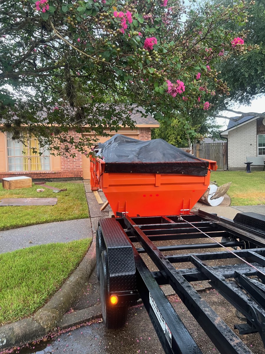 Loaded roll-off dumpster tarped down before haul-off