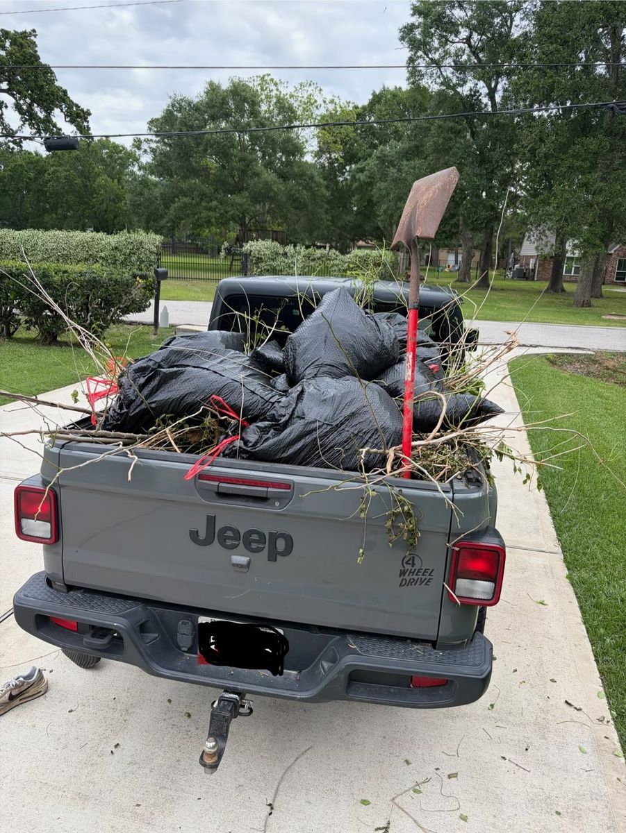 Truck bed loaded with bagged junk and yard debris for haul-off