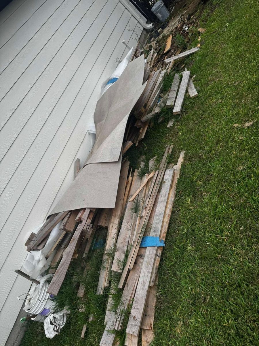 Old fence panels and lumber stacked for haul-off
